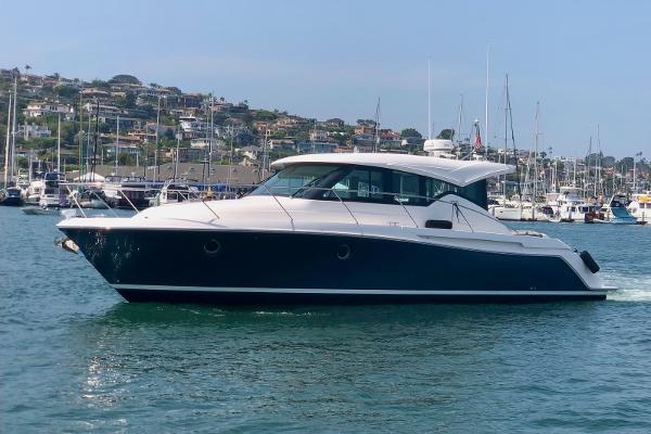 Slide: The Image of 2020 Tiara Yachts 39 Coupe cruising in a marina with scenic background. - 0