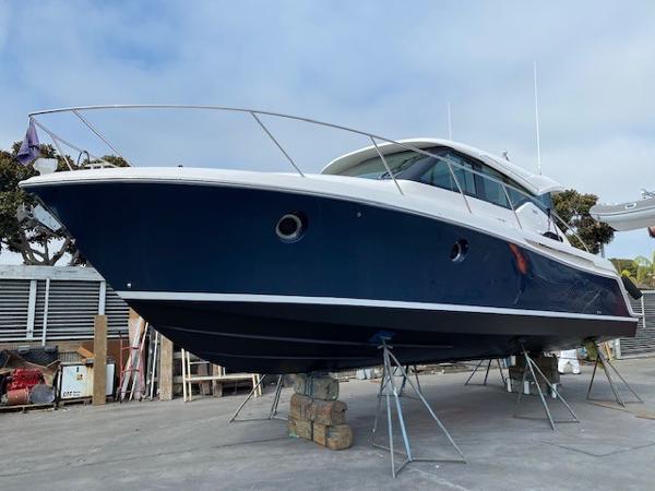 Slide: The Image of 2020 Tiara Yachts 39 Coupe on stands, blue hull, dockside view. - 3