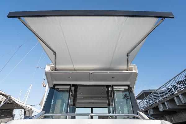Slide: The Image of 2020 Tiara Yachts 39 Coupe with extended canopy, docked under clear blue sky. - 6