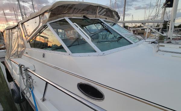 Slide: The Image of 1996 Tiara Yachts 4000 Express docked at sunset, featuring sleek design and clear windows. - 7