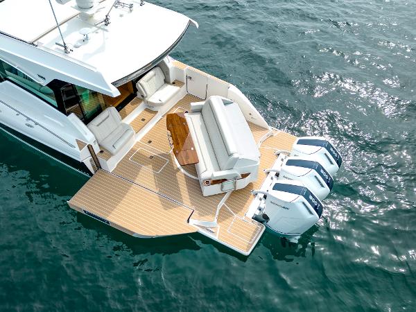 Slide: The Image of 2025 Tiara Yachts 48LE luxury boat with triple outboard engines on water. - 2