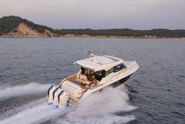 Slide: The Image of 2025 Tiara Yachts 48LE cruising on open water near a scenic coastline. - 3