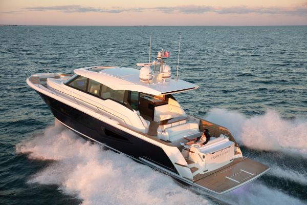 Slide: The Image of 2025 Tiara Yachts EX 60 cruising on open water at sunset. - 1