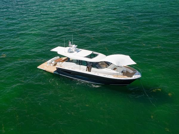 Slide: The Image of 2025 Tiara Yachts EX 60 luxury yacht on clear green water. - 10