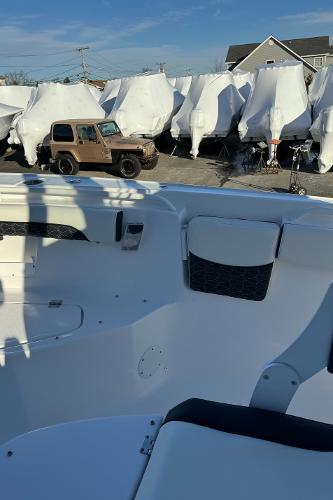 Slide: The Image of 2024 Tidewater 256 LXF boat in storage yard with covered boats. - 12