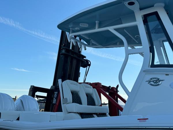 Slide: The Image of 2024 Tidewater 256 LXF boat with white seating and blue T-top. - 2