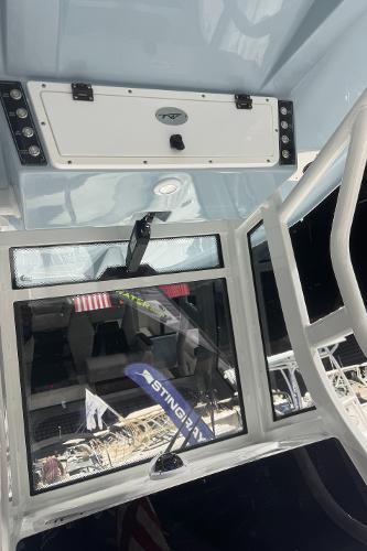 Slide: The Image of 2024 Tidewater 256 LXF boat interior with storage compartment and window. - 37