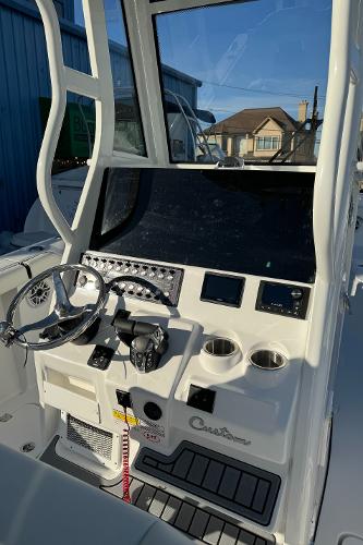 Slide: The Image of 2024 Tidewater 256 LXF boat console with steering wheel and control panel. - 7