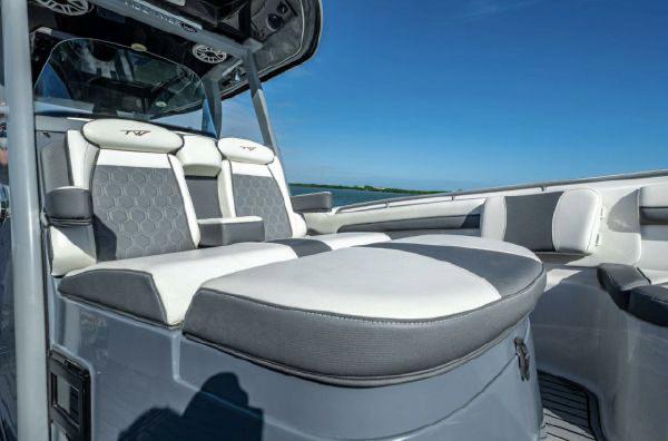 Slide: The Image of 2020 Tidewater 320 CC Adventure boat interior with cushioned seating under clear blue sky. - 10