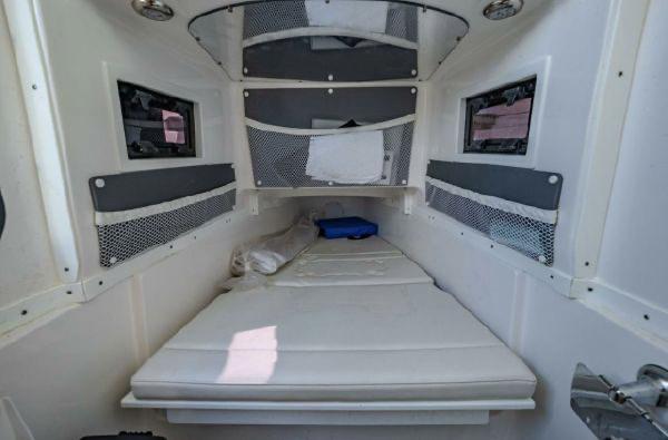 Slide: The Image of 2020 Tidewater 320 CC Adventure cabin interior with white bedding and storage nets. - 13