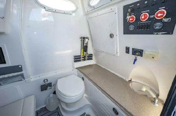 Slide: The Image of 2020 Tidewater 320 CC Adventure boat interior with toilet and control panel. - 14