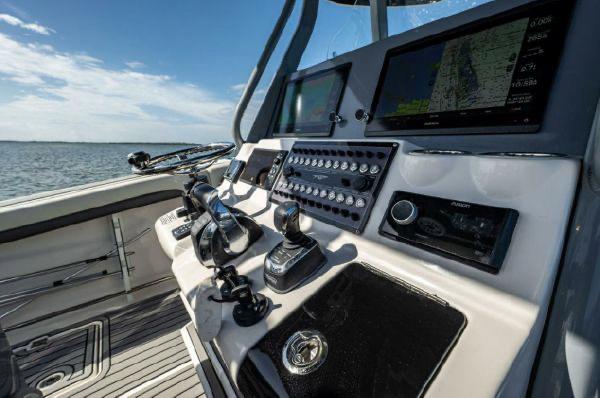 Slide: The Image of 2020 Tidewater 320 CC Adventure boat dashboard with advanced navigation controls on open water. - 15