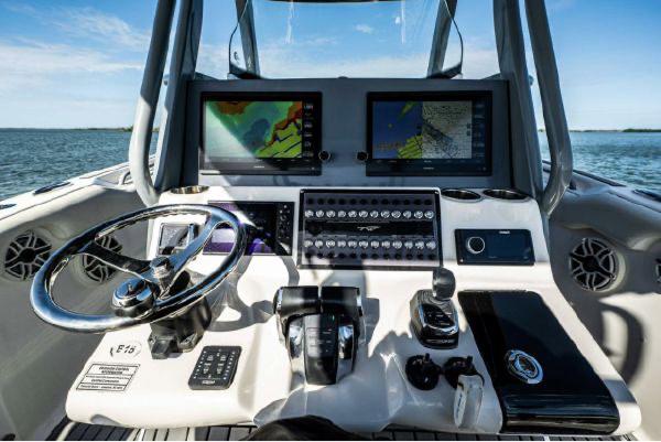 Slide: The Image of 2020 Tidewater 320 CC Adventure boat dashboard with dual navigation screens and controls. - 17