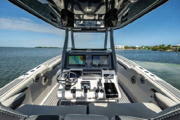 Slide: The Image of 2020 Tidewater 320 CC Adventure boat cockpit with advanced navigation system on open water. - 18
