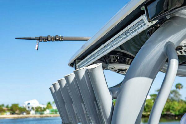 Slide: The Image of 2020 Tidewater 320 CC Adventure boat with rod holders and blue sky background. - 19