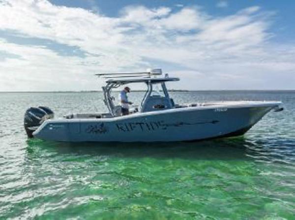 Slide: The Image of 2020 Tidewater 320 CC Adventure boat on clear water under a blue sky. - 2