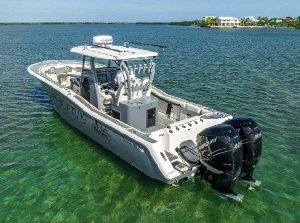 Slide: The Image of 2020 Tidewater 320 CC Adventure boat with dual Mercury engines on clear water. - 23