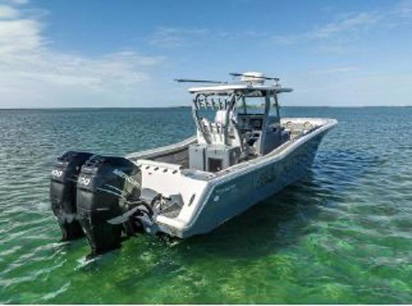 Slide: The Image of 2020 Tidewater 320 CC Adventure boat on clear water, featuring dual engines. - 25