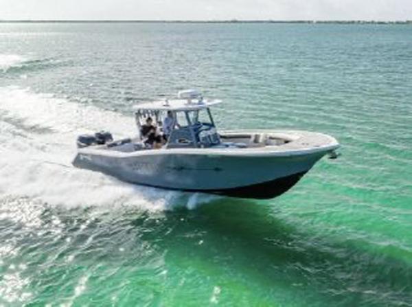 Slide: The Image of 2020 Tidewater 320 CC Adventure boat cruising on clear turquoise waters. - 30