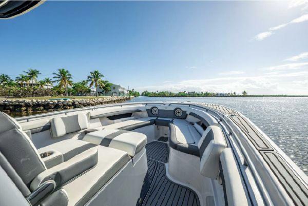 Slide: The Image of 2020 Tidewater 320 CC Adventure boat with spacious seating, docked near a tropical shoreline. - 7
