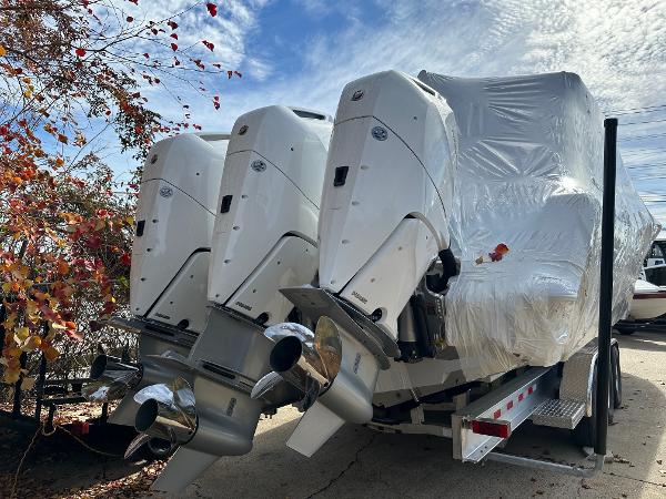 Slide: The Image of 2024 Tidewater 380 CC Adventure boat with triple engines, wrapped for transport. - 1