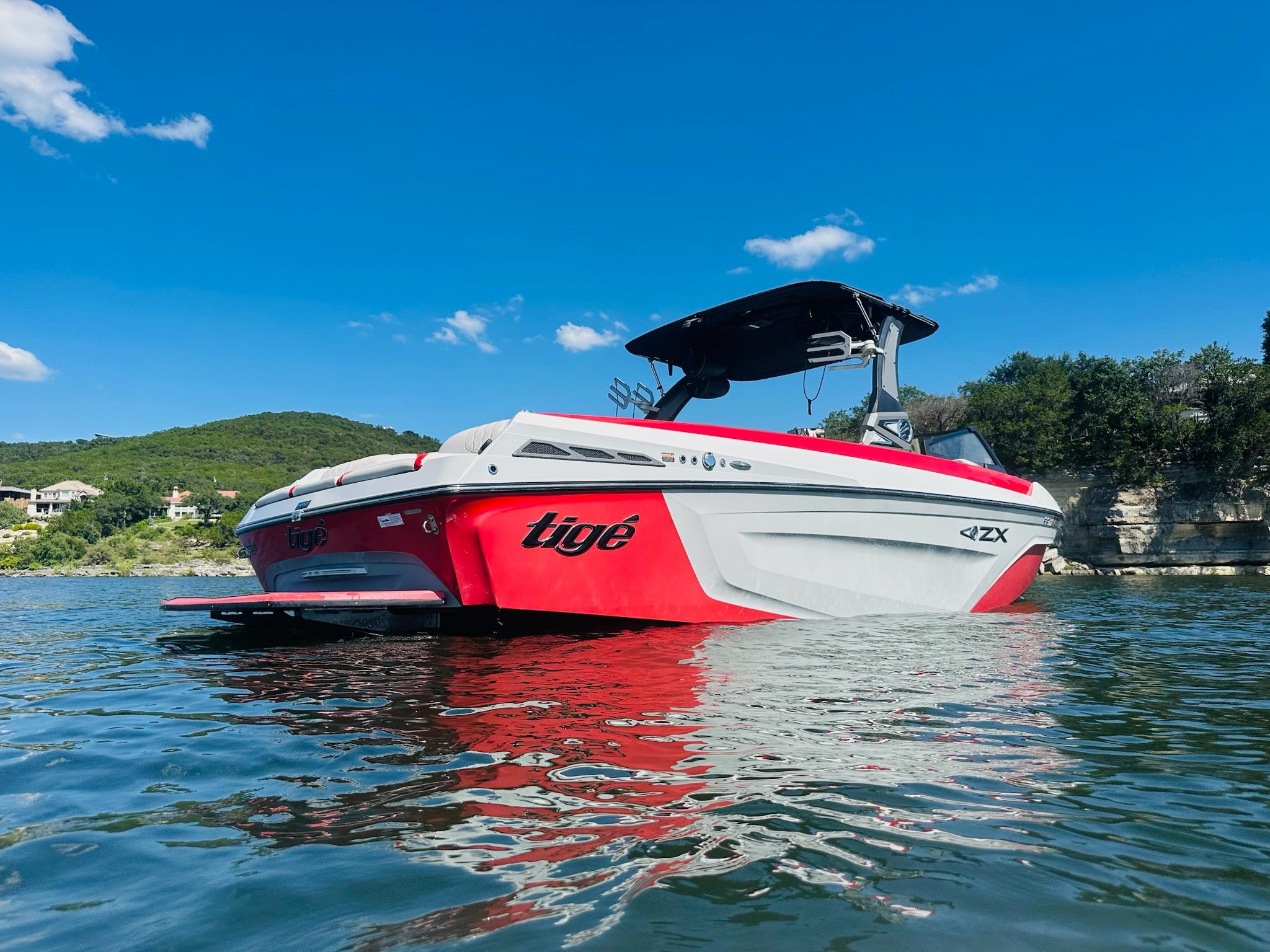 Slide: The Image of 2020 Tigé 25ZX boat on a lake with clear blue sky. - 1