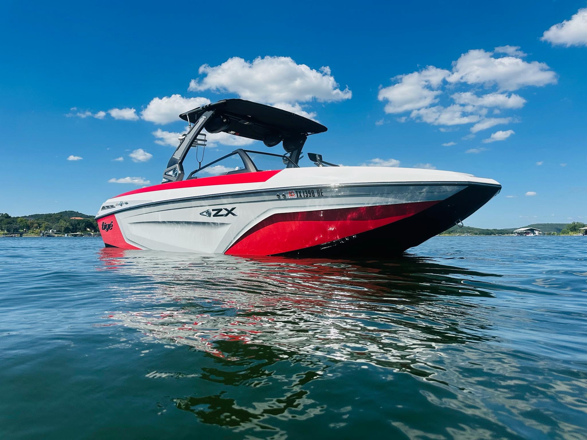 Slide: The Image of 2020 Tigé 25ZX boat on water under clear blue sky. - 2