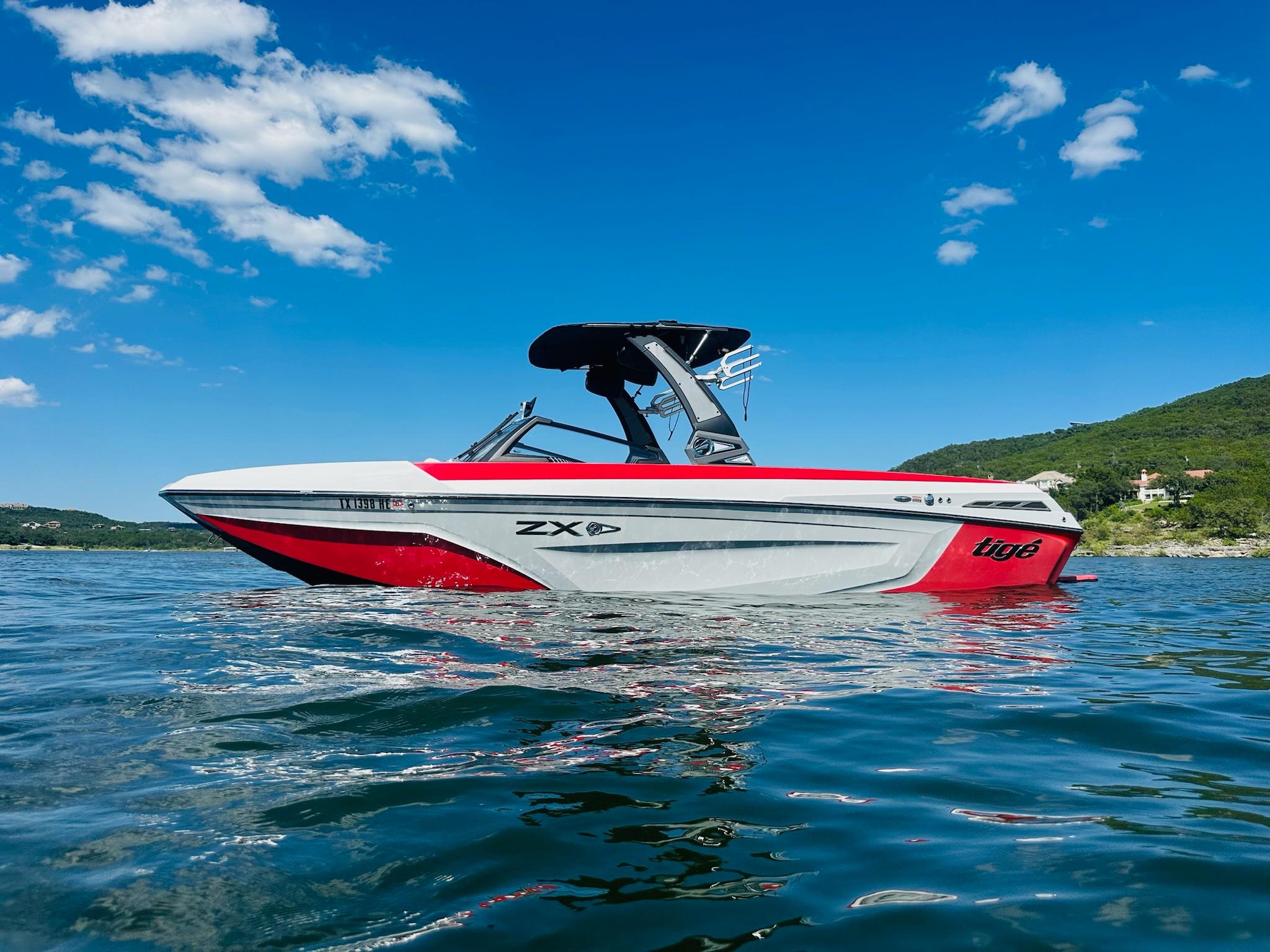 Slide: The Image of 2020 Tigé 25ZX boat on a sunny lake with clear blue skies. - 3