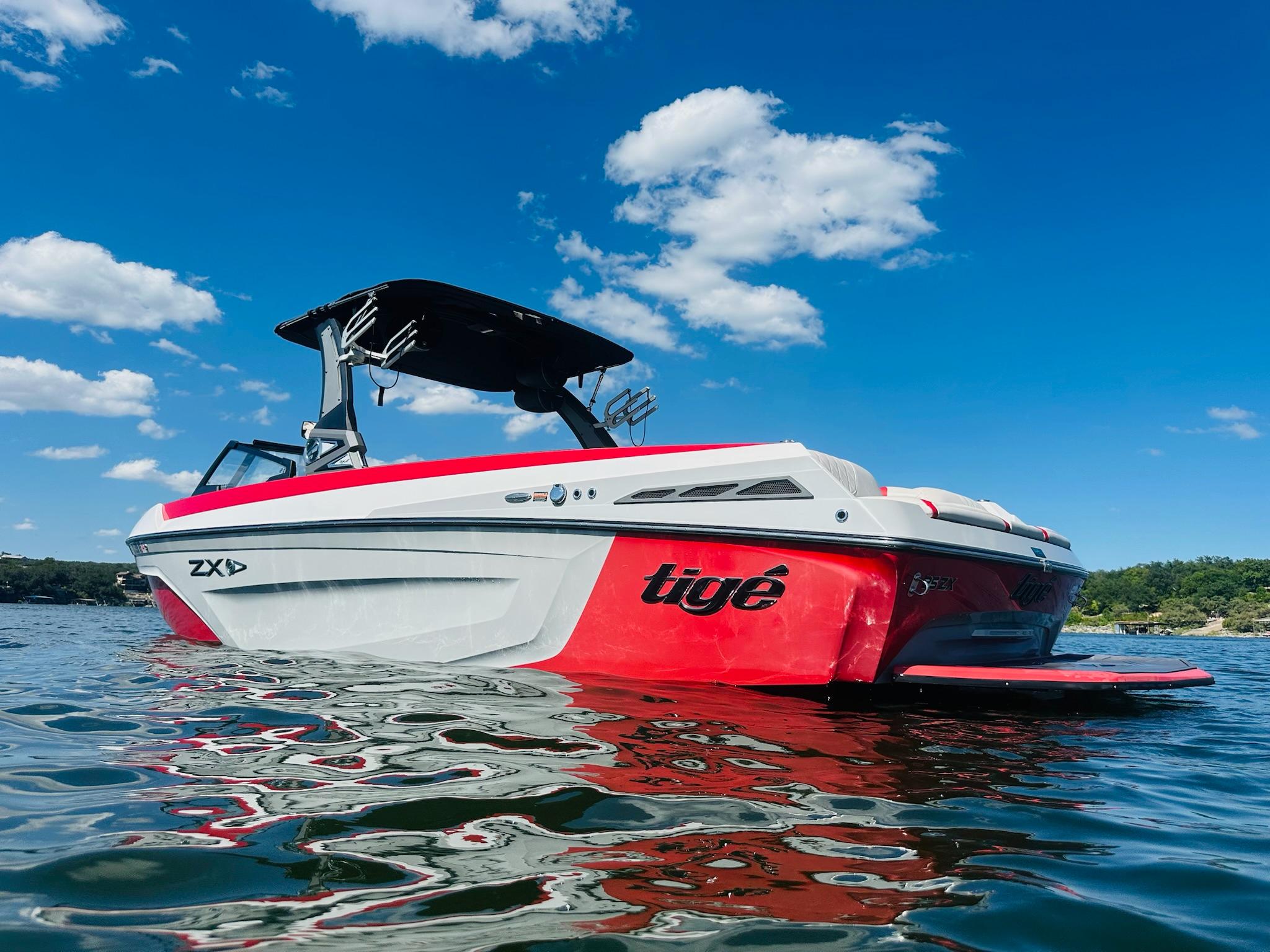 Slide: The Image of 2020 Tigé 25ZX boat on water under clear blue sky. - 4