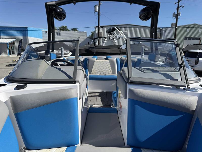 Slide: The Image of 2019 Tigé R21 boat interior with blue and gray seating, open windshield, and outdoor setting. - 11