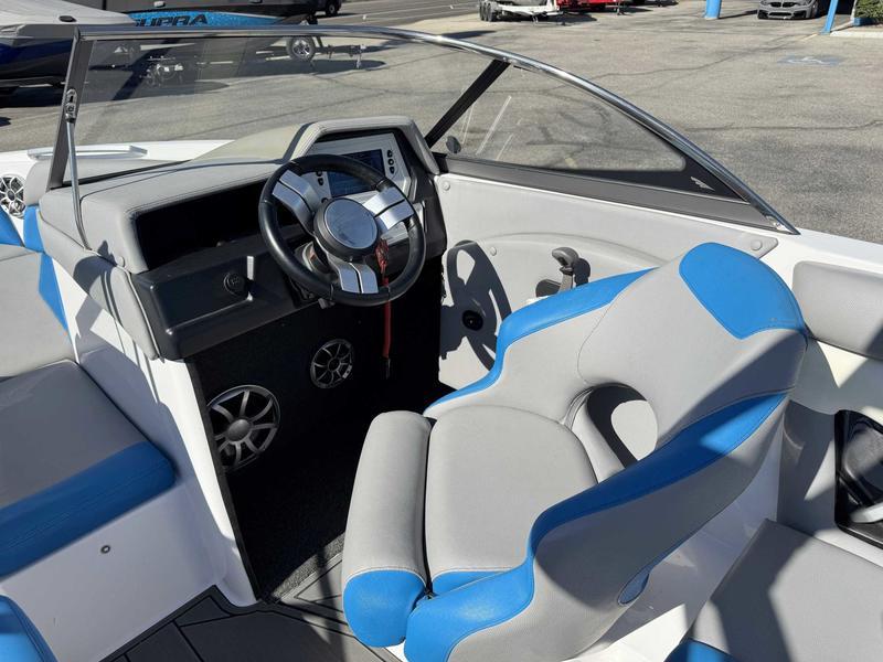 Slide: The Image of 2019 Tigé R21 boat interior with steering wheel and blue-gray seating. - 12