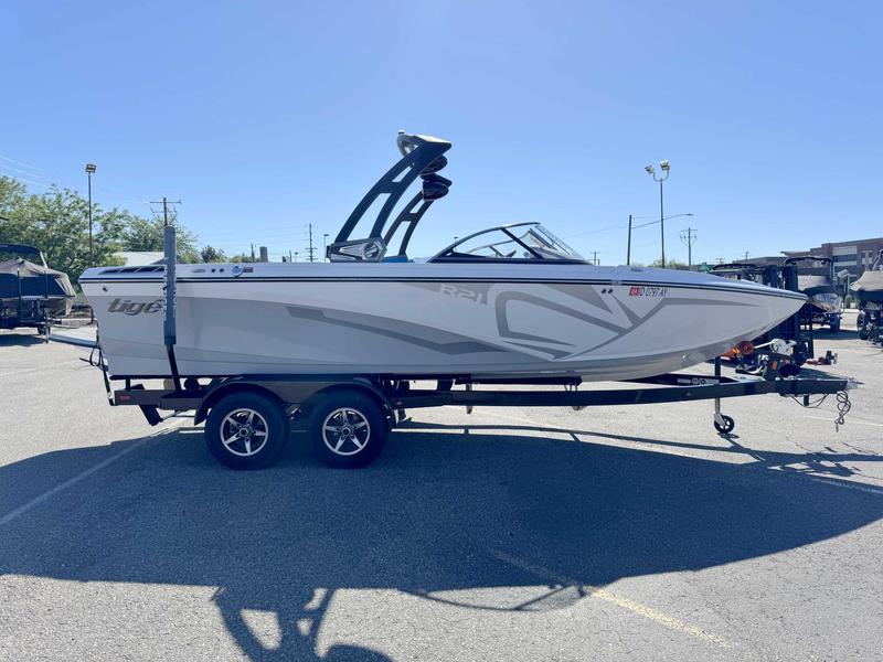 Slide: The Image of 2019 Tigé R21 boat on trailer in parking lot under clear blue sky. - 7