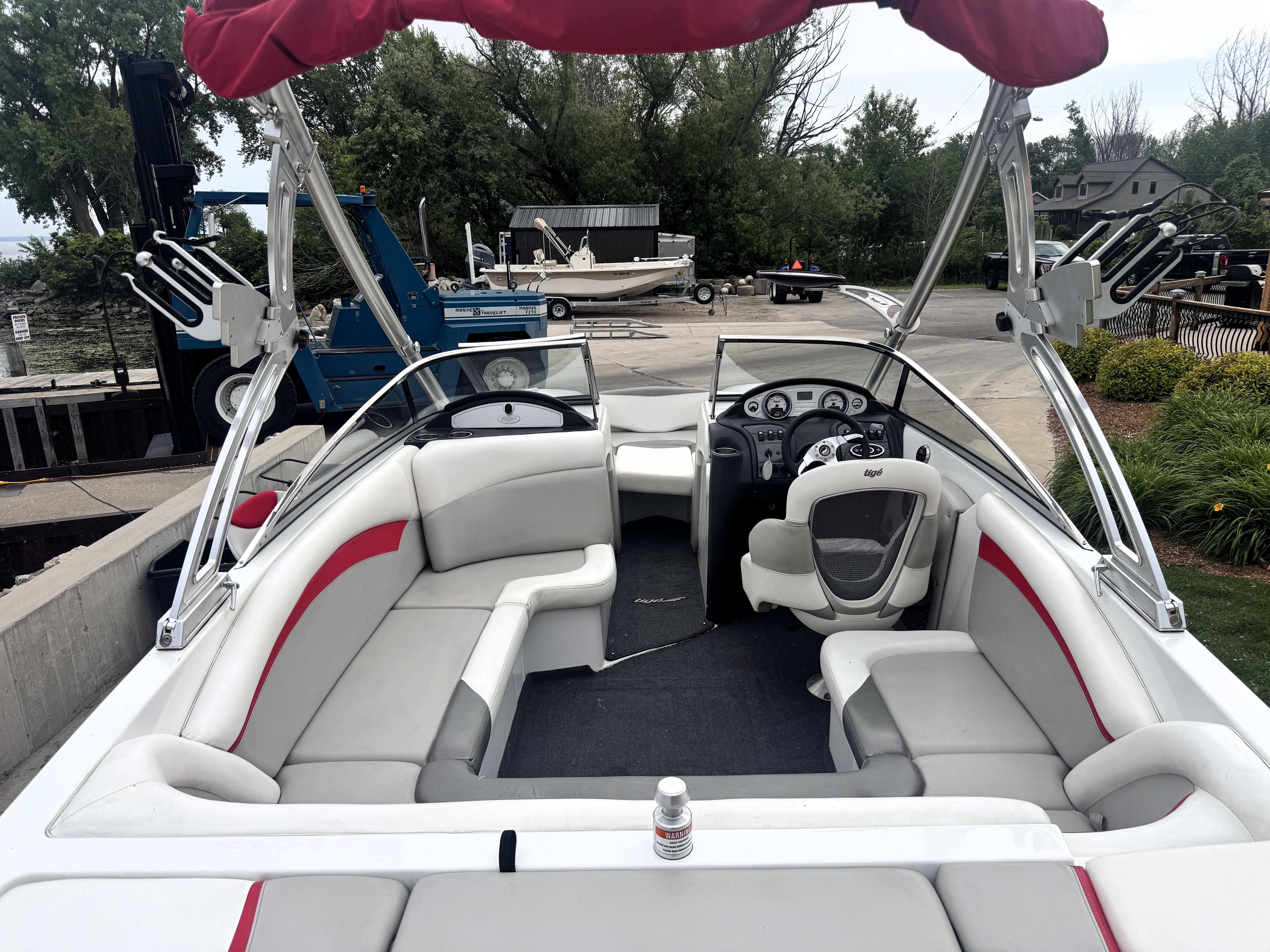 Slide: The Image of 2007 Tigé RZ2 boat with red canopy, spacious seating, and modern dashboard. - 18