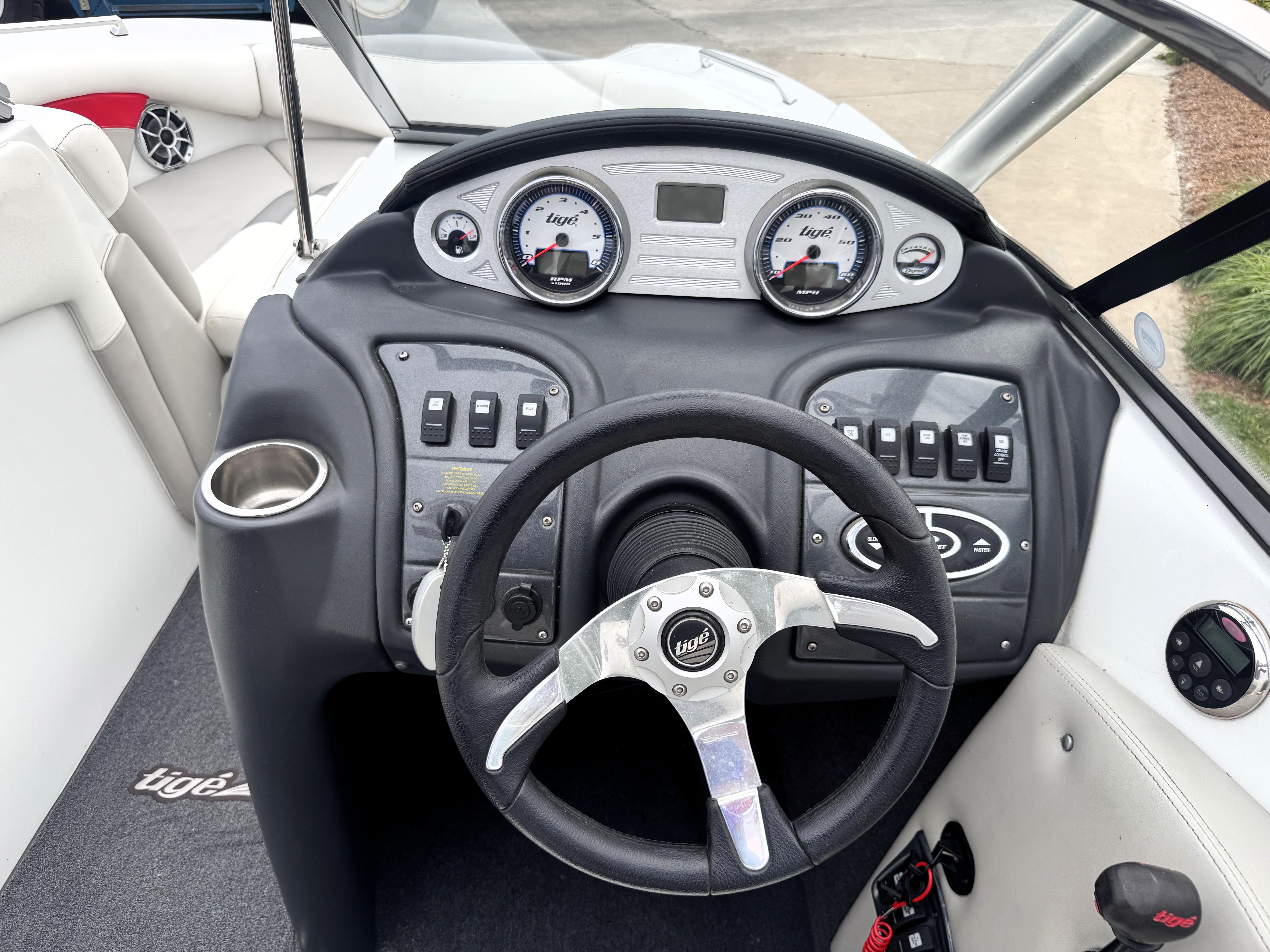 Slide: The Image of 2007 Tigé RZ2 boat dashboard with steering wheel, gauges, and control switches. - 21