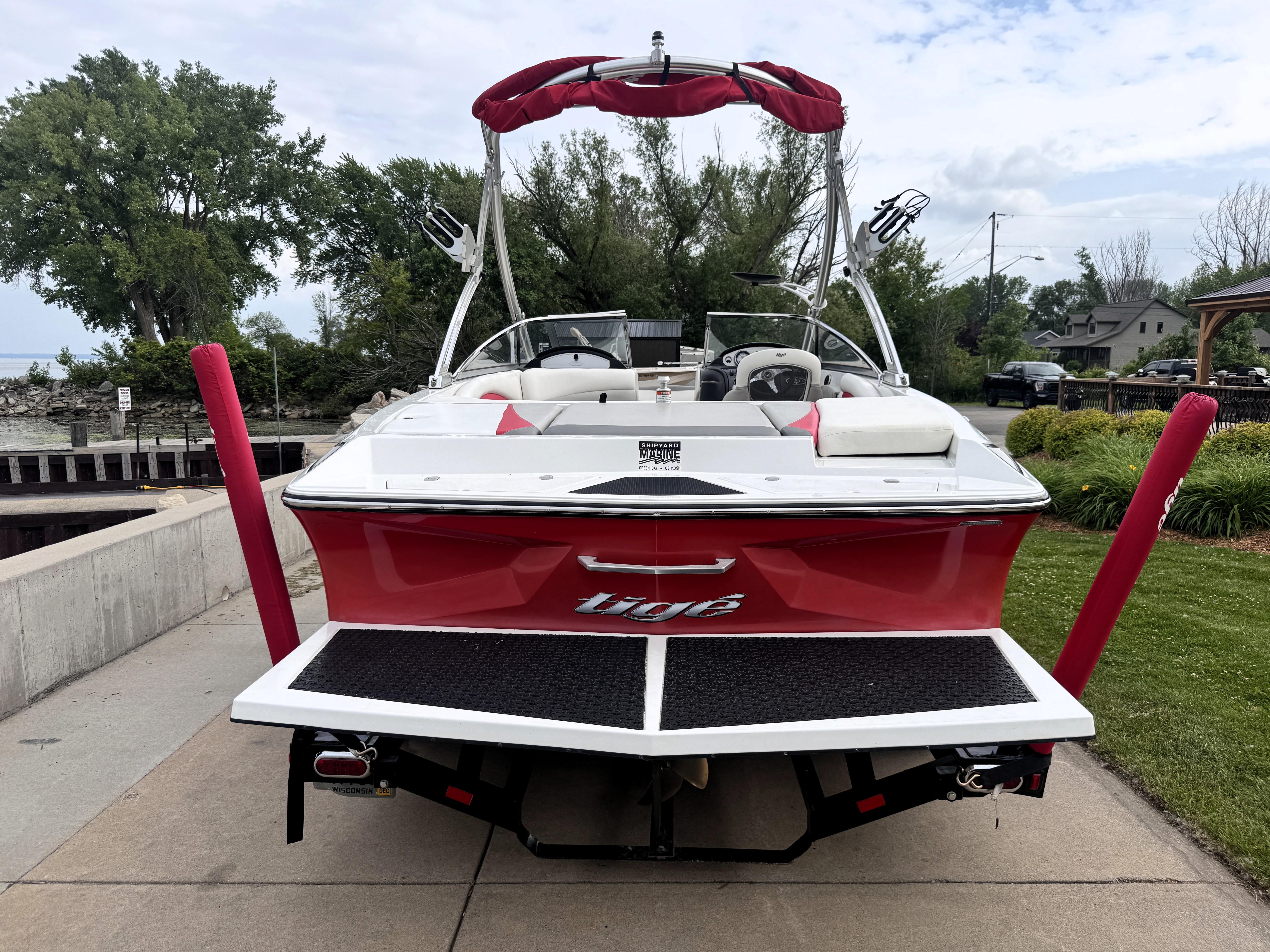 Slide: The Image of 2007 Tigé RZ2 boat with red and white design, parked on a concrete driveway. - 5