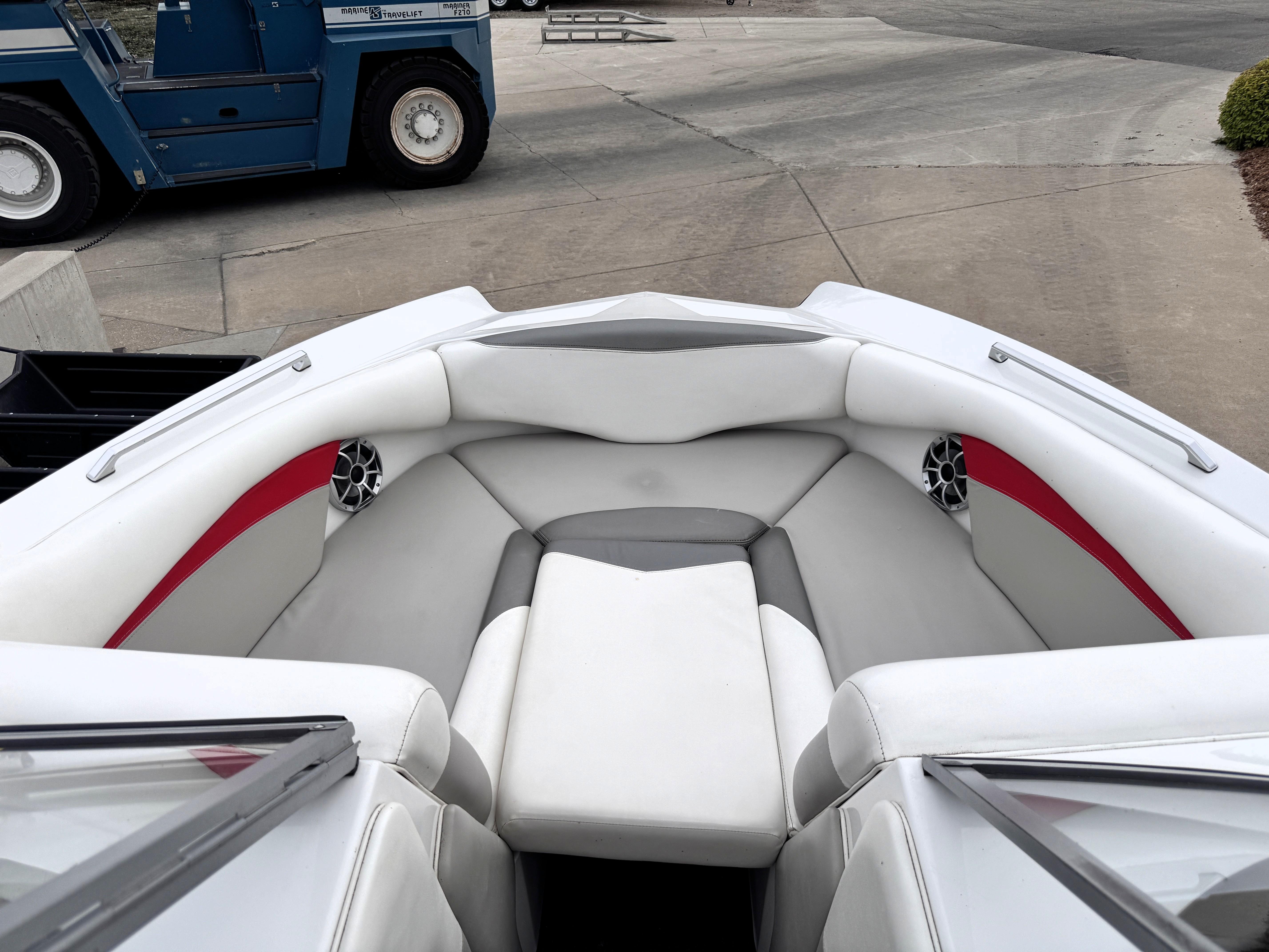 Slide: The Image of 2007 Tigé RZ2 boat interior with white and red seating, docked on concrete. - 7