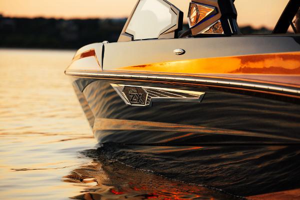 Slide: The Image of 2024 Tigé ULTRA ZX 23 and 25 boat on calm water at sunset. - 10