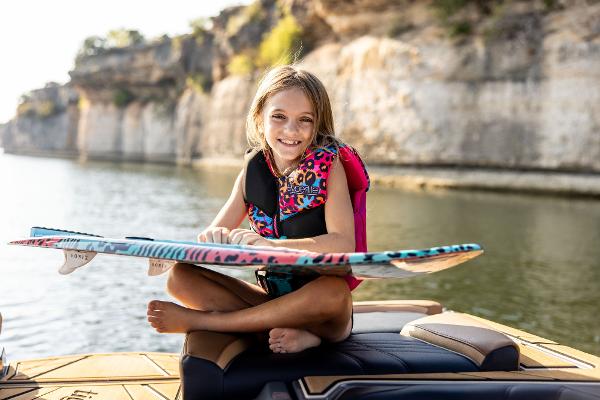 Slide: The Image of Young girl on Tigé ULTRA ZX 23 boat holding a colorful wakeboard, 2024 model. - 19