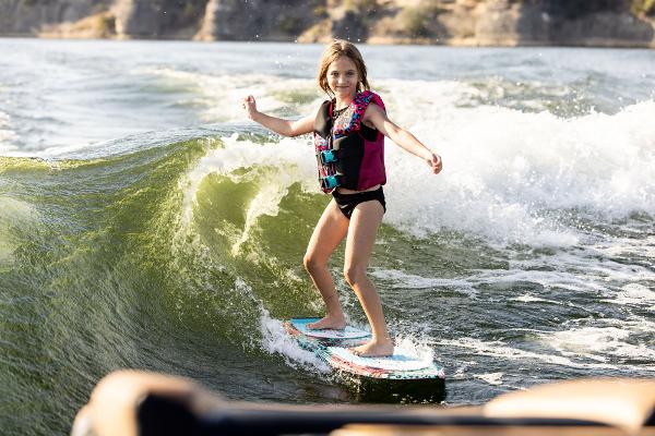Slide: The Image of Young girl wakesurfing behind a 2024 Tigé ULTRA ZX 23 and 25 boat. - 20