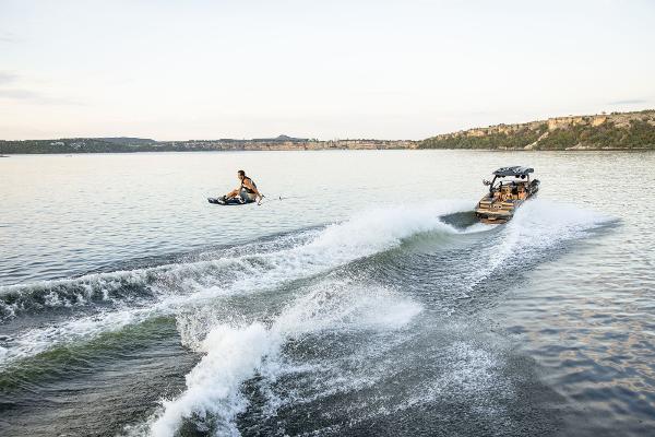 Slide: The Image of 2024 Tigé ULTRA ZX 23 and 25 boat towing a wakeboarder on a lake. - 31