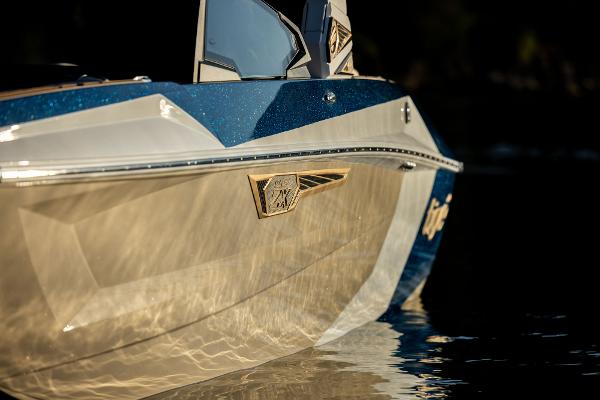 Slide: The Image of 2024 Tigé ULTRA ZX 23 and 25 boat, sleek design reflecting on water. - 36