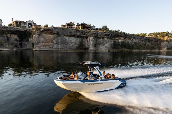 Slide: The Image of 2024 Tigé ULTRA ZX 23 and 25 boat cruising on a scenic lake. - 38