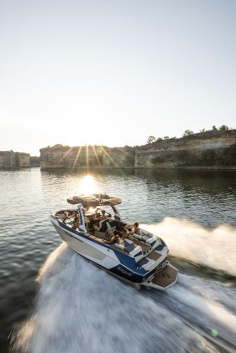 Slide: The Image of 2024 Tigé ULTRA ZX 23 and 25 boat cruising on a lake at sunset. - 39