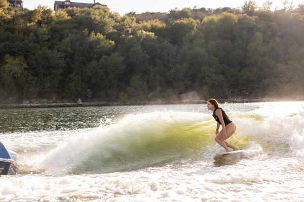 Slide: The Image of 2024 Tigé ULTRA ZX 23 and 25 boat creating waves for wakesurfing on a scenic lake. - 41