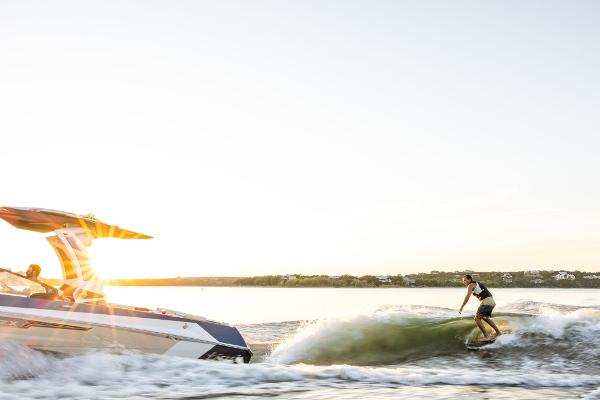 Slide: The Image of 2024 Tigé ULTRA ZX 23 and 25 boat with a wakeboarder at sunset. - 46