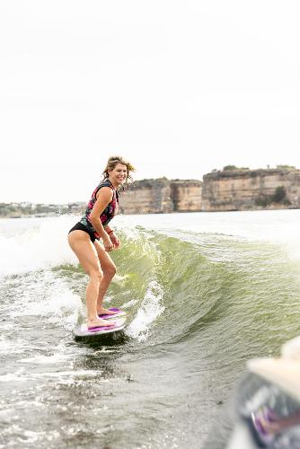 Slide: The Image of Woman wakesurfing behind 2024 Tigé ULTRA ZX 23 and 25 boat on a lake. - 48