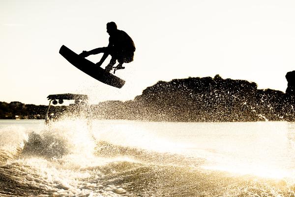 Slide: The Image of Wakeboarder jumping behind 2024 Tigé ULTRA ZX 23 and 25 boat at sunset. - 49