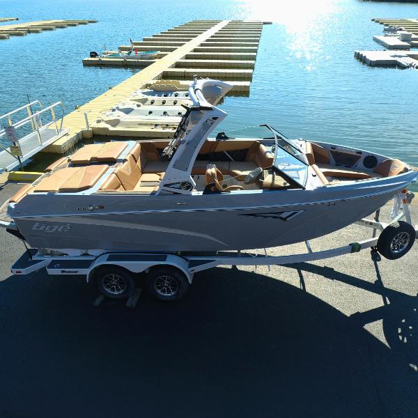 Slide: The Image of 2024 Tigé Z1 boat on trailer by the dock, ready for launch. - 2