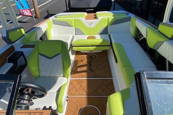 Slide: The Image of 2021 Tigé Z3 boat interior with green and white seating, brown flooring, and steering wheel. - 11