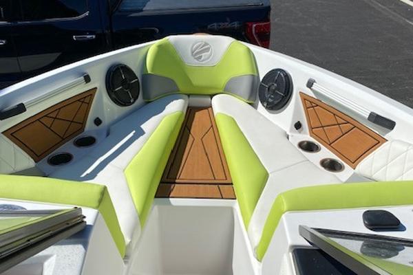 Slide: The Image of 2021 Tigé Z3 boat interior with lime green and white seating, wood accents, and cup holders. - 13